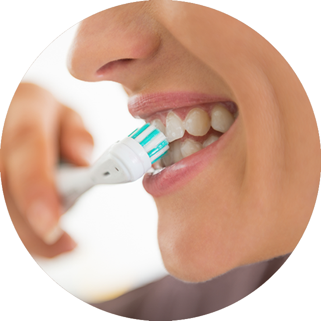 Lady brushing her teeth to prevent tooth decay